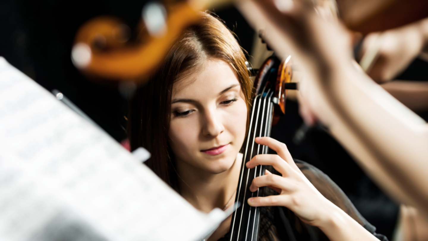 Violinist playing amongst an orchestra